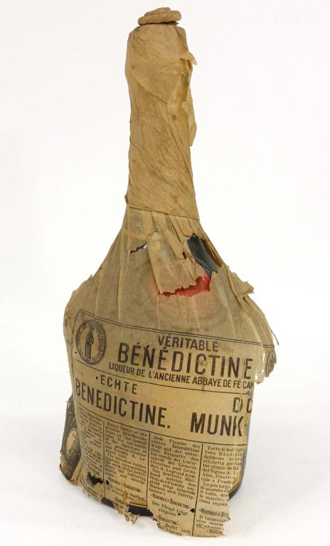 Bottle - Veritable Benedictine Liqueur: 25/32 Qt., 86 Proof. Still wrapped in most of original paper wrap. If you anticipate needing bottles shipped you MUST talk to Ian PRIOR to BIDDING! 847-625-0555.