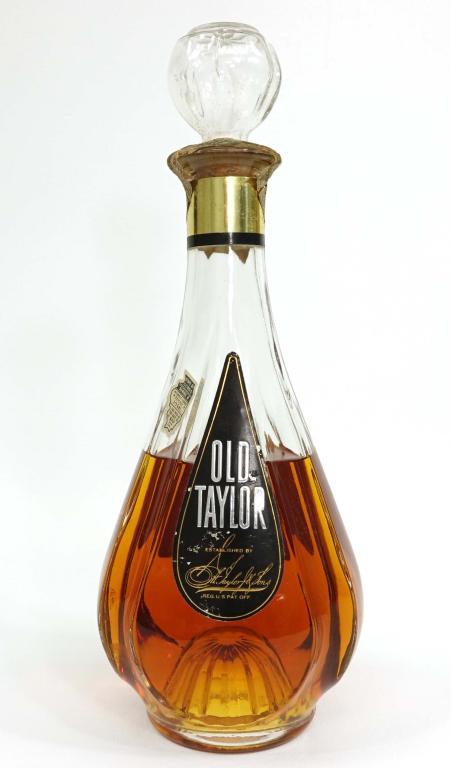 Old Taylor Bourbon Whiskey Bottle: ***If you anticipate needing bottles shipped you MUST talk to Ian PRIOR to BIDDING! 847-625-0555.*** Bottle: Old Taylor Bourbon Whiskey. 4/5 qt, 100 proof, and sealed.