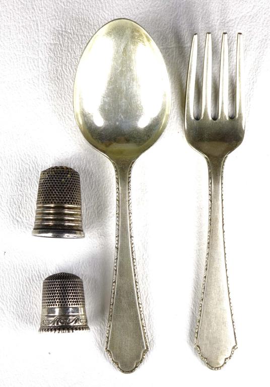 Sterling Silver Lot: A fork, spoon and two thimbles, all marked as sterling silver. 40.9 grams total mass.