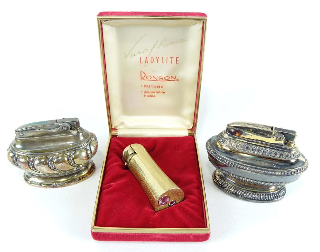 Vintage Ronson Lighters: 1 Vara Flame Ladylite goldtone; 1 "Crown" silverplate table lighter (mechanism is jammed); 1 "Queen Anne" silverplate table lighter.