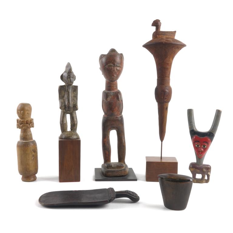 African Carvings - 20th Century: Comprising of a Senufo male figure, a female figure, a carving with an elephant and a face, a horn snuff or patch box, a finial, a paddle, and an Indonesian lime container. Tallest is 16".