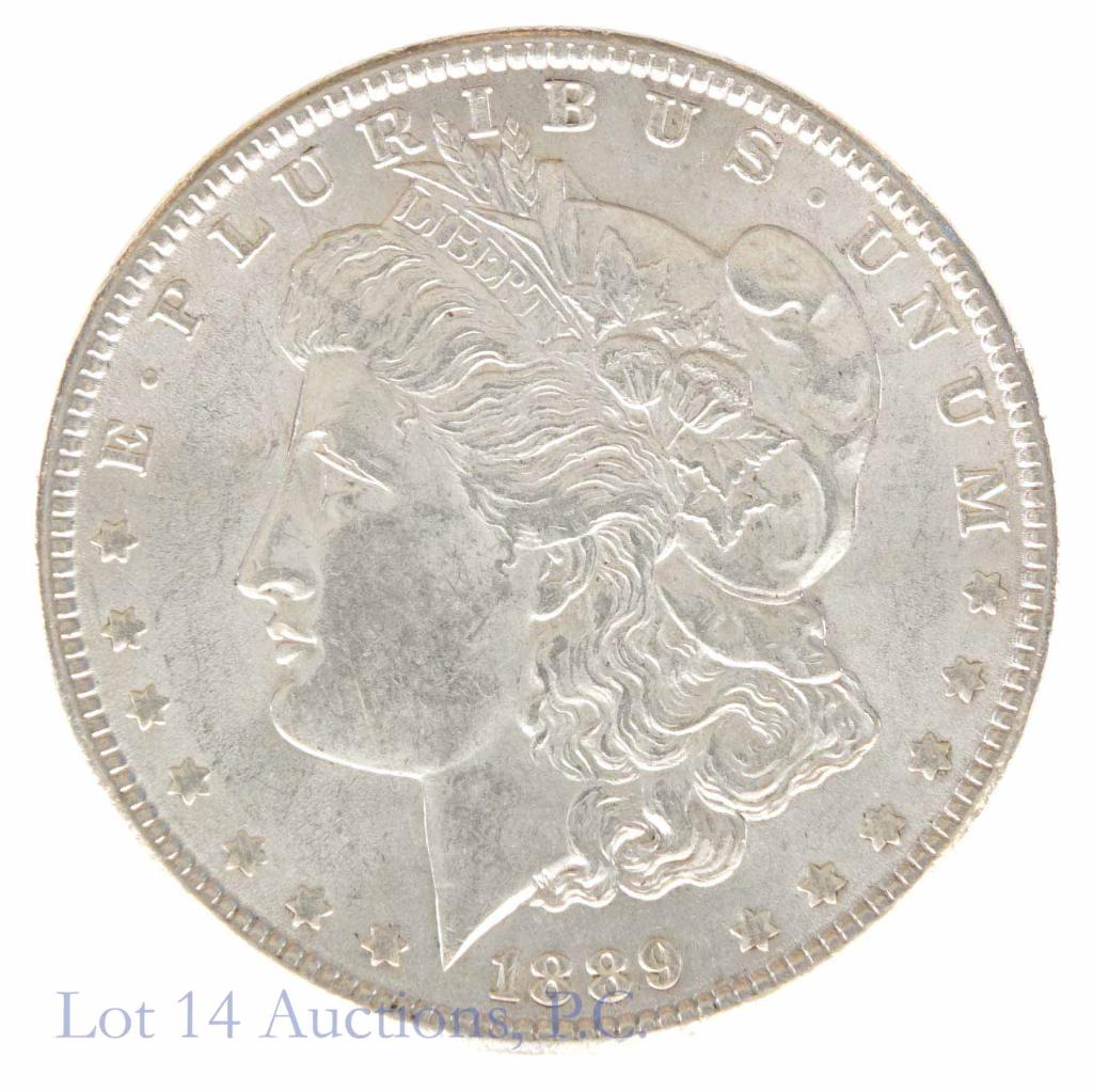 1889 Morgan Silver Dollar (BU?): 1889 Morgan dollar (Philadelphia Mint). 90% silver. Per consigner, brilliant uncirculated (BU). *** Please note: we at Lot 14 Auctions are not professional coin graders. We are NOT grading these coins
