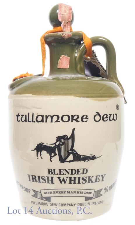 Tullamore Dew Irish Whiskey in Jug - 4/5 Quart: Tullamore Dew Blended Irish Whiskey in earthenware jug. 86 proof, 4/5 quart. Series 112 (Internal Revenue) tax strip (1961-1977). Neck tag present. **Tax strip is torn, but cloth lace is still under t