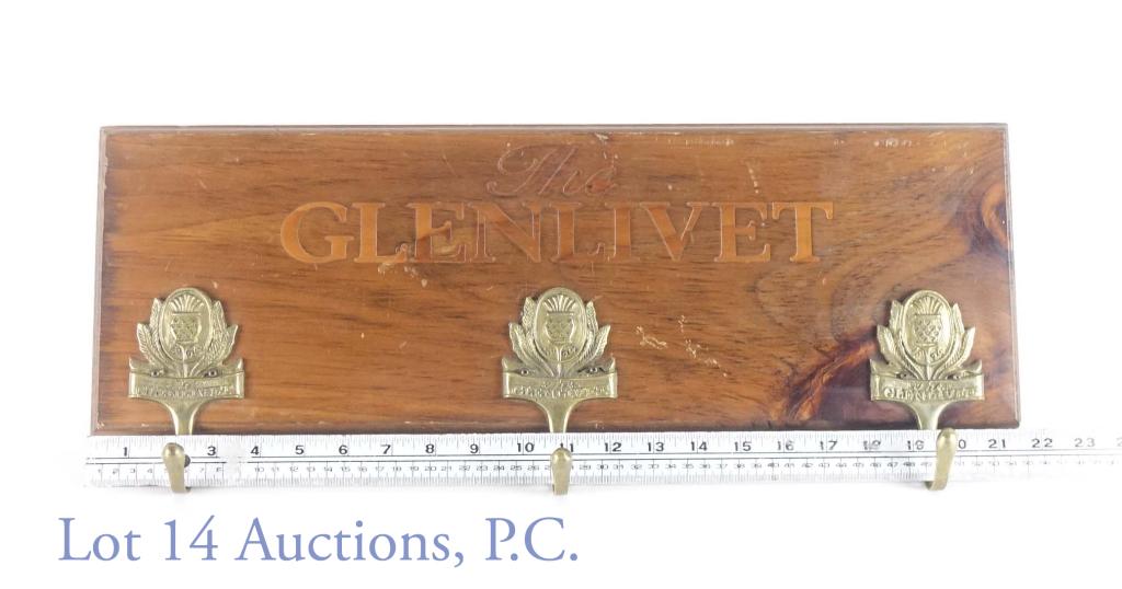 The Glenlivet Coat Hooks: Glenlivet coat hooks. Wooden plaque with The Glenlivet inscribed and three coat hooks. Minor chips and scratches in wood. Approximate dimensions: 7.5 x 22.5" . (See photo for condition details.)