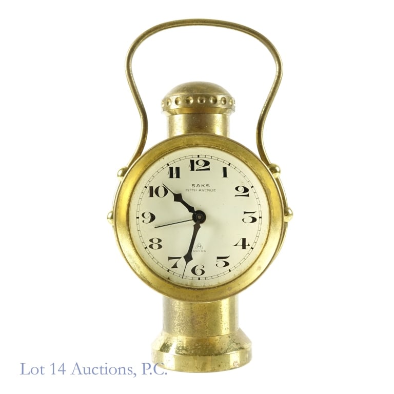Saks Fifth Avenue Desk Clock: Swiss made desk clock branded by Saks Fifth Avenue. Crystal is missing. Bottom of base is engraved "70 739". Back of the clock is engraved "1486247". Oxidation throughout the brass, and some scratches