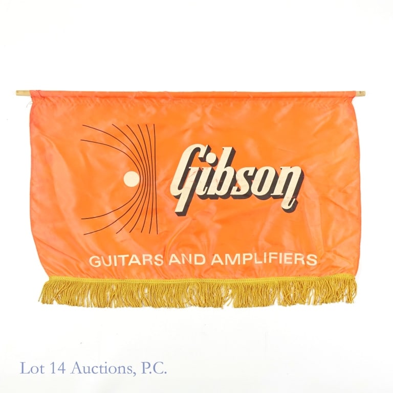 Gibson Guitars & Amplifiers Store Display Banner: Gibson Guitars and Amplifiers orange colored with gold tassel trim store display banner. We think the material may be nylon or a similar artificial material. Approximately 31.25" x 20.5". Some stainin