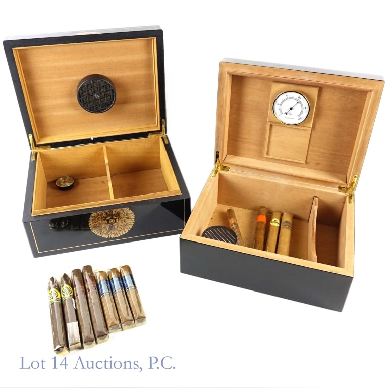 Humidors (2) + Cigars: 2 enamel and wood humidors. Approximately 12.5" x 10" x 5". Both have signs of light wear with streaks and scratches. This lot includes 11 cigars all still wrapped, though per consigner, some may be e
