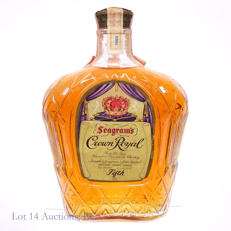 1964 Crown Royal Fine De Luxe Canadian Whisky: Crown Royal Fine De Luxe Canadian Whisky, 80 Proof, 4/5 Quart, Distilled: 1964. Tax strip stained and torn in multiple places but intact overall. Front and back labels are both slightly torn and badly