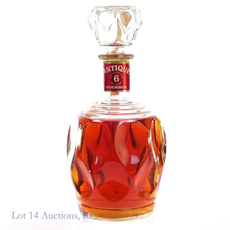 "69" Antique 6 Year Bourbon**: Antique 6 Year Bourbon, 86 Proof, 4/5 Quart, early 1960s-late 1970s tax strip, "69" glass molding****tax strip torn in multiple places and hanging on by a thread but still intact. Due to the fragility