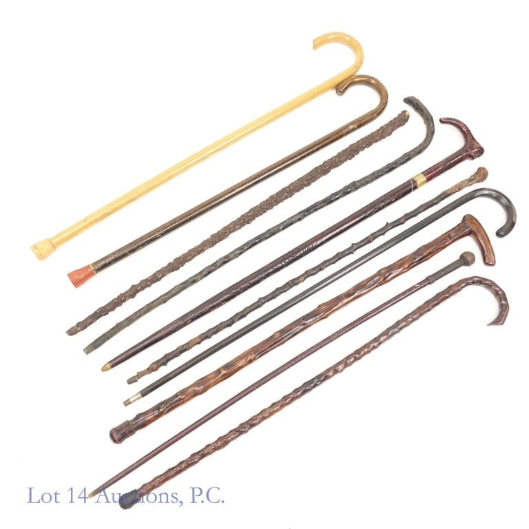 Canes, Walking Sticks, and a Stick: Collection of 11 canes, walking sticks, and one stick. The one stick appears to be a swagger stick of some kind. 22.25" long with a thong at one end and a small eyelet at the other. There is one sword