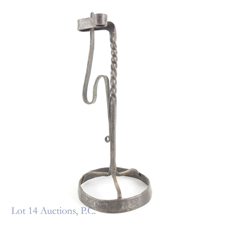 Wrought Iron Primitive Candlestick: Wrought Iron Primitive Candlestick. 13" x 5" wrought iron primitive candlestick believed to be circa 18th/19th century. Item is sturdy, light sticker remnant. See photos for more details on condition.