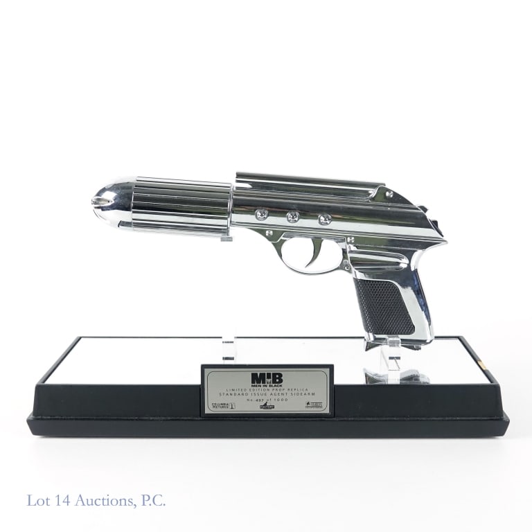 Men In Black Agent Sidearm Model Gun: Includes a Men in Black limited edition prop replica standard issue agent sidearm gun. This model is numbered 497 out of 1000. The model takes batteries. There is a 1 inch chip on the laminate of the 