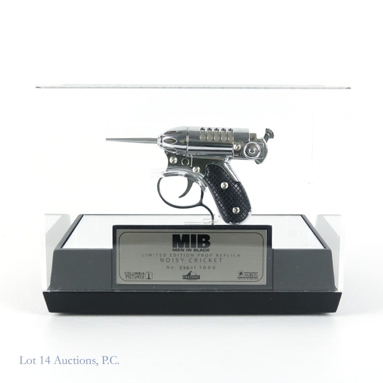 Men In Black Noisy Cricket Replica: Includes a 236 out of 100 prop replica of the noisy cricket gun from Men In Black. Also includes base and acrylic cover with an about 2.25" crack on one side. The gun is approximately 4.75" by 3". No 