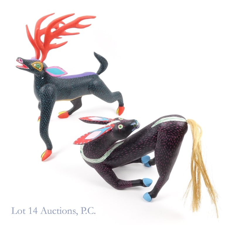 Large Mexican Wooden Animal Figurines (2): 2 large figurines made of Oaxacan wood with intricate patterns and colors. One figurine depicts an otherworldly figure with a black body, purple spine, teal stripes, and orange and yellow hoofs. It is