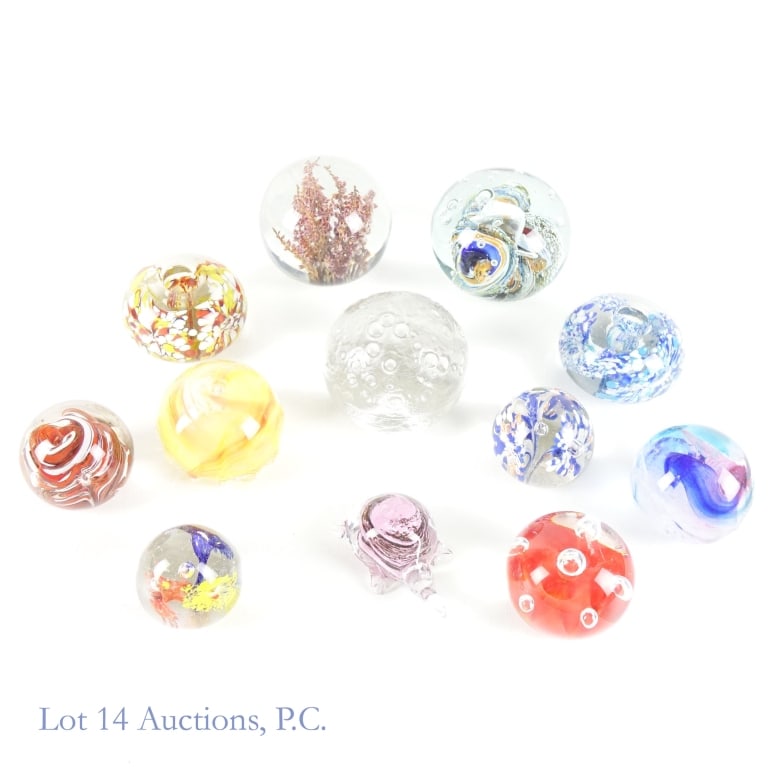 Art Glass Paperweights (11): Art Glass Paperweights (11). A collection of eleven (11) glass paperweights as well as one (1) possible acrylic. Items appear free from damage with some sticker remnants remaining. See photos for more