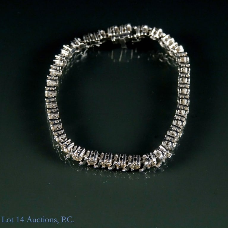 14k W Gold Diamond Tennis Bracelet: White gold bracelet with 35 round cut diamonds. Marked "14k". Electronically tests as 14 karat gold. Gems electronically test as diamonds. Hidden clasp with lock. Approximately 5-7/8" long. Total weig
