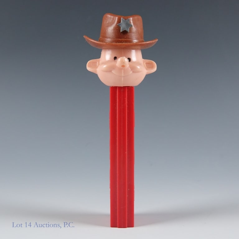PEZ Dispenser, Sheriff, 3.8, U.S.A.: PEZ Dispenser, Sheriff, 3.8, U.S.A. PEZ Sheriff, #3.845.882, Made in U.S.A., Red Stem, Spring working, Head loose, No feet, Light wear on stem, Discolorations on hat. See photos for more details on co