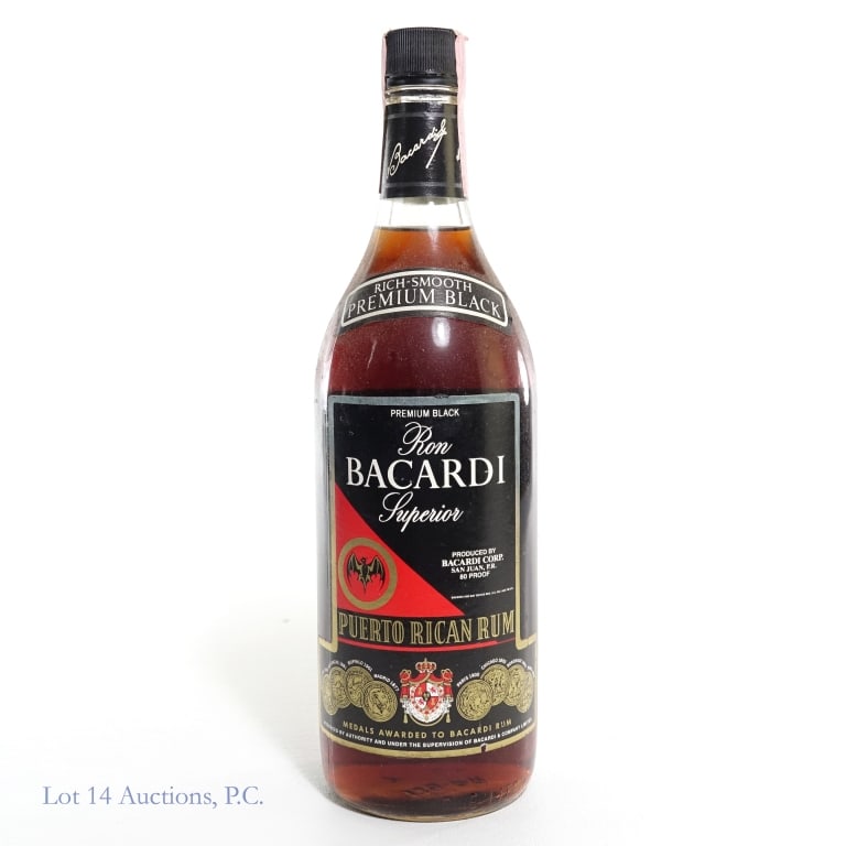 1980s Bacardi Superior Premium Black Rum (1 Liter): Bacardi Superior Premium Black Puerto Rican Rum, 80 Proof, 1 Liter, "87" glass molding. Tax strip torn and slightly stained but intact overall. Slight nicks and minor wear to front and back labels. Pl