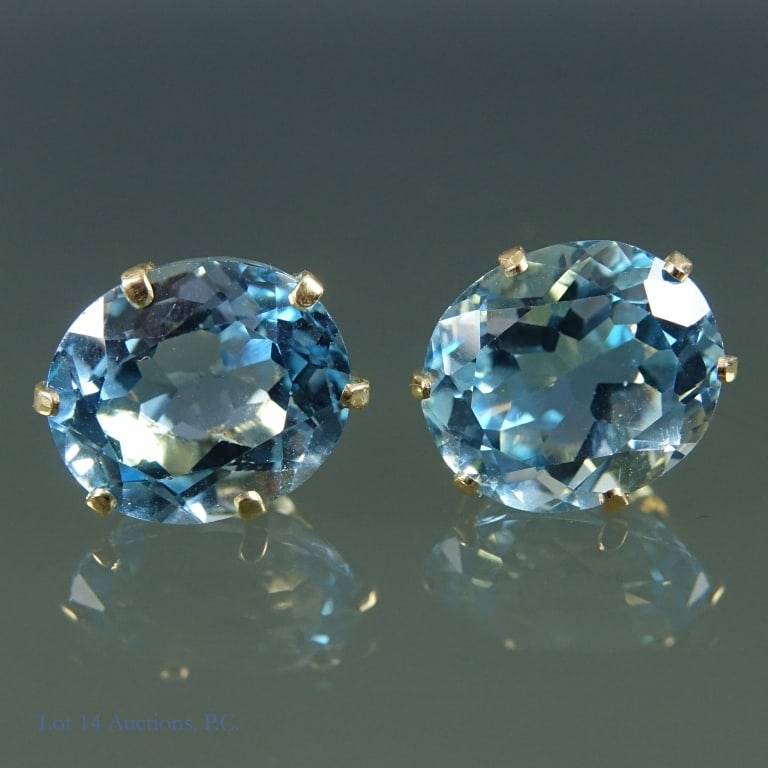 14K Y Gold and Blue Topaz Earrings: Pair of yellow gold earrings with large light blue topaz gemstones. Earrings and backs are both marked "14K" and has a gemstone with an "F" in it. Gem electronically tests as topaz. Total weight of th