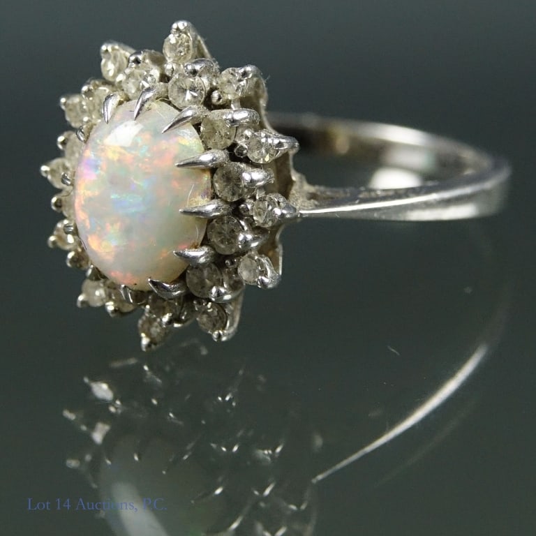 14k W Gold Opal Diamond Ring: White gold ring with central opal surrounded by 24 small diamonds (electronically test as diamond. Marked "Garland" and "14K". Electrically tests for 14 karat gold. Weight: 4.35 grams. Size 10.5.