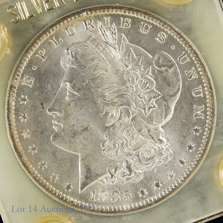 1885-O USA Silver Morgan Dollar (BU): 1885-O United States silver Morgan dollar (New Orleans Mint). Designer is George T. Morgan. Per consigner, grades BU and comes in Lucite holder. Metal is 90% silver, weighs 26.73 grams and diameter me