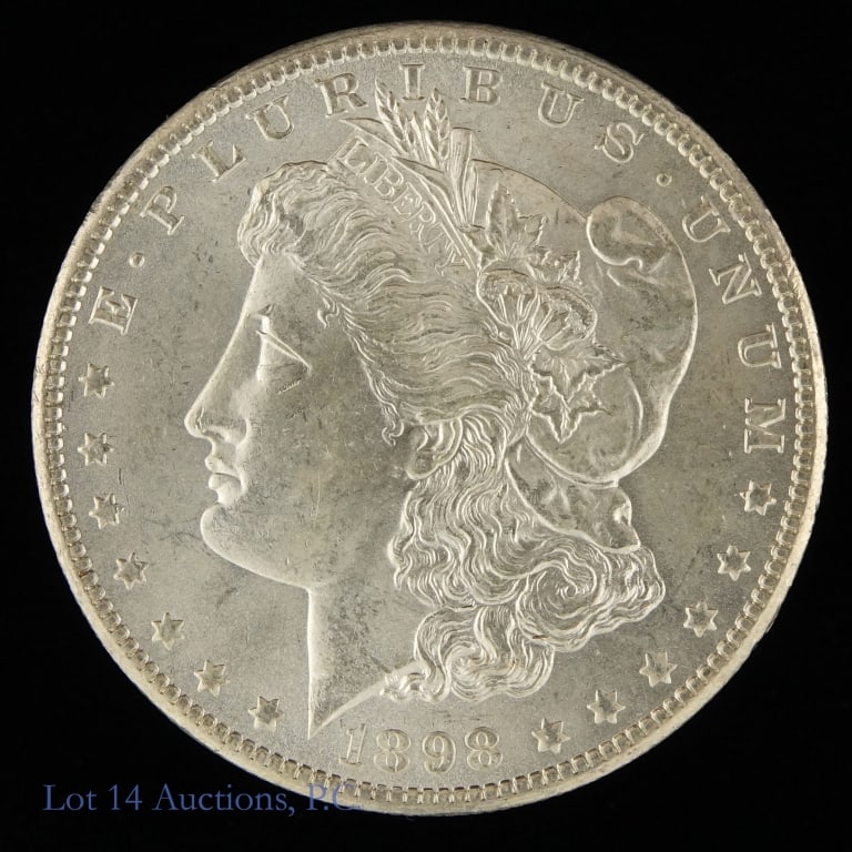 1898-O USA Silver Morgan Dollar (CH BU): 1898-O United States silver Morgan dollar (New Orleans Mint). Designer is George T. Morgan. Per consigner, grades CH BU with clean cheek and great surfaces. Metal is 90%-silver, weighs 26.73 grams and