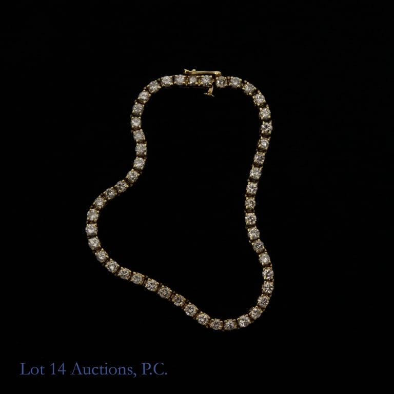 14k Yellow Gold Diamond Tennis Bracelet: Yellow gold tennis bracelet with 49 round-cut stones in 4-prong settings and a bracelet catch style clasp. Marked "14k". Tests electronically for 14 karate gold. Stones test electronically as diamond.