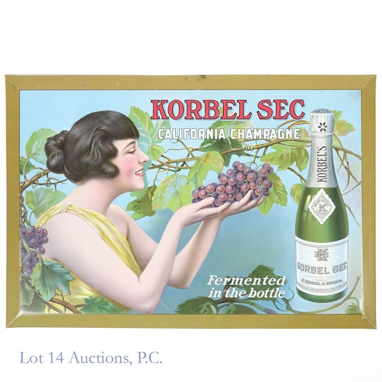 Korbel Sec California Champagne Sign: Advertisement for Korbel Sec California Champagne featuring a picture of the bottle next to a woman holding grapes, surrounded by a grapevine. 19''x13''. Tin over cardboard, with cardboard stand on th