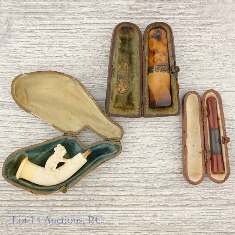 Meerschaum - 3 Cigarette Holders & Pipes: Three pipe cases holding antique pipes, cigarette holders, or parts of pipes. Two appear to be broken or missing some pieces. One is whole, and the inside of its case reads "Warranted Real Meerschaum"