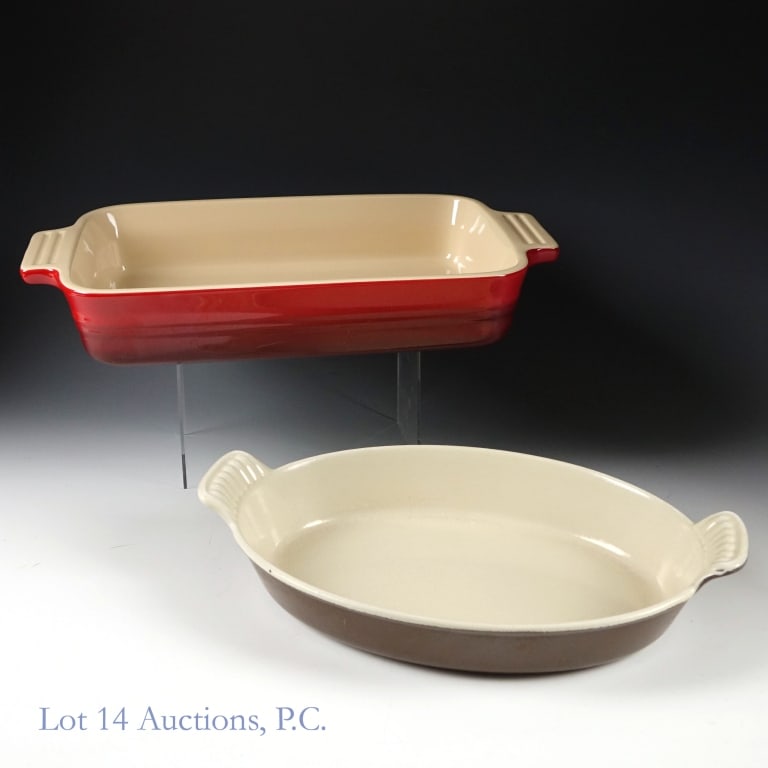 Le Creuset Enameled Cookware (2): Two pieces of Le Creuset enameled Cookware: a red 10.5''x7'' rectangular roaster, and a brown 9.5''x7'' oval au gratin. Both in good condition, though the oval au gratin has some scratches and signs o