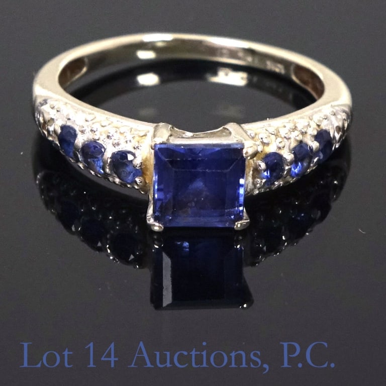 10k White Gold & Blue Topaz Ring, Size 4.75: 10k white gold ring, size 4.75, 1.9g (1.24dwt) total weight. Approximately .5ct center square topaz with 6 small topaz.