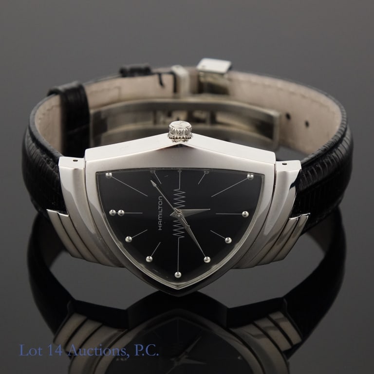 Hamilton Ventura Watch H244110: Hamilton Ventura Watch. Model H244110. Black dial and black leather band. With original box. Seems to be a few scratches on the case and buckle. See photos for more details on condition.