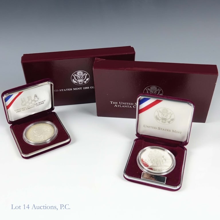 1988s & 1995 USA 90%-Silver Olympic $1 in OGP (2): *** PLEASE NOTE: At time of photography, the outer sleeve for the 1988-s coin was missing. It has been found and is now with the lot. *** Two (2) United States Mint silver Olympic commemorative dollar