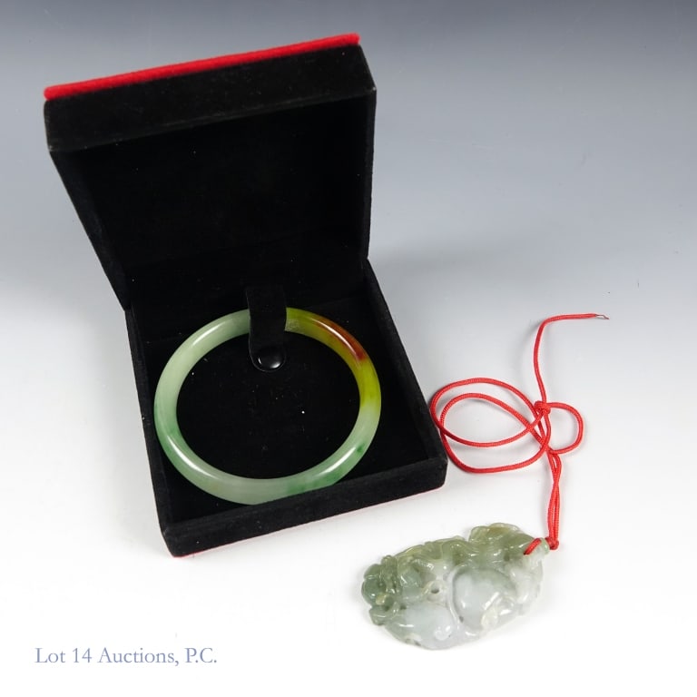 Jade Bangle & Carved Pendant: Small red and black velvet jewelry box containing a green jade bangle with a yellow-brown spot and an intricately carved jade pendant. The pendant measures to approximately 2.5" long. Both in very goo