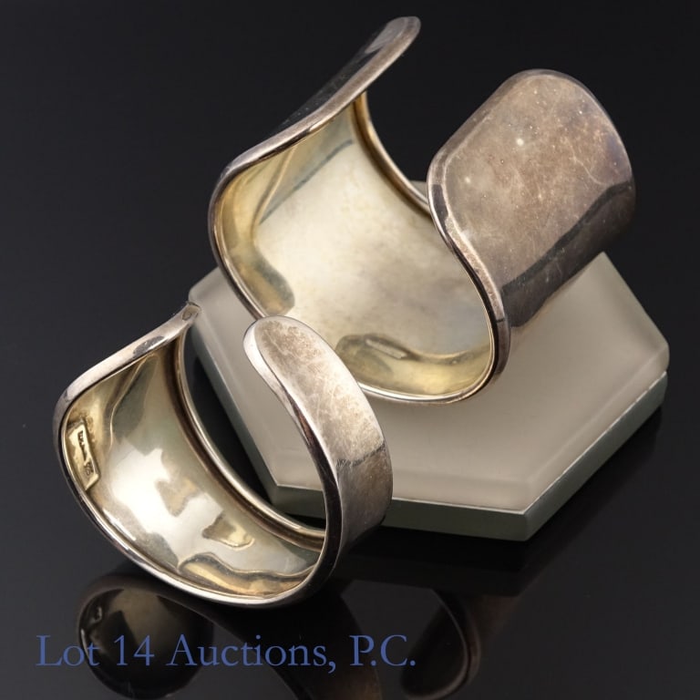 Sterling Silver Cuff Bracelets, 3ozt.t.w. (2): Two (2) sterling silver cuff bracelets, Total weight: 95g. The smaller bracelet has an outer circumference of approximately 5.75". Gap is approximately 5/8". Marked with an unknown designer's signatur