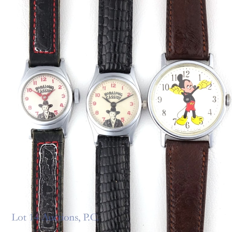 Hopalong Cassidy & Mickey Mouse Watches (2+1): Hopalong Cassidy hand winding wrist watch with original leather strap. 22.5 mm case and white Hopalong Cassidy dial. Watch winds and runs but has not been tested for accuracy or power reserve ***