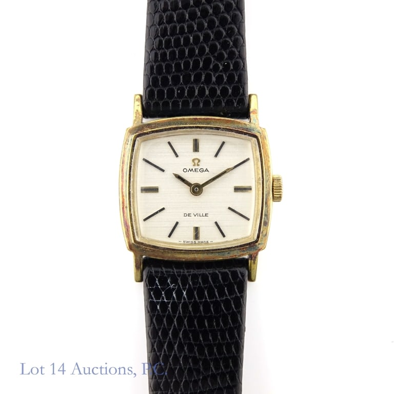 Omega De Ville Women's Mechanical Watch: Omega De Ville women's hand winding wrist watch. Gold tone 22.5 mm square dial with black lizard strap. Off white satin dial with gold tone applied stick indices and hands. Watch is winding and