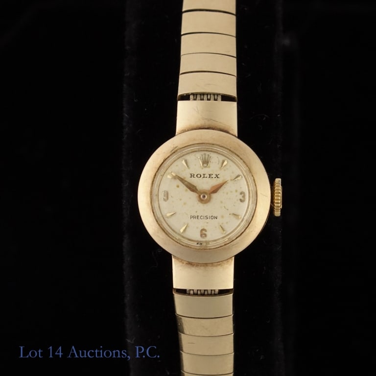 Ladies 9k Y. Gold Rolex Precision Watch: 9k yellow gold Vintage Rolex watch with original bracelet. Bracelet is marked and tests as 9k. Watch case is also 9k gold. 15mm case diameter. Total weight: 16g. With genuine Rolex watch. Lot 14
