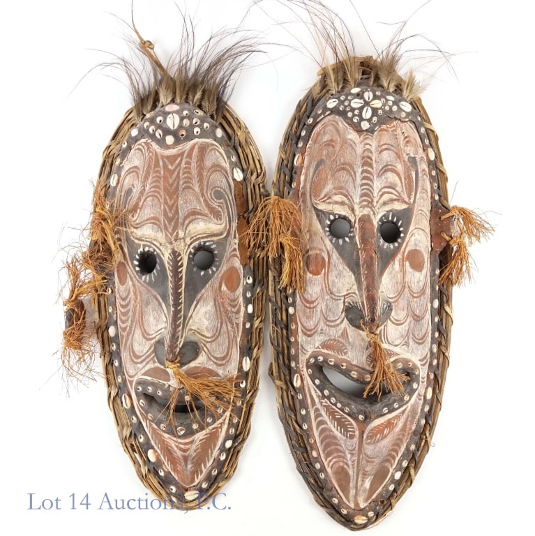 Sepik River Papua New Guinea Tambaran Mask (2): Two (2) Sepik River region Papua New Guinea hand-carved wood, shells and feathers Tambaran mask. Approximately 22" and 24" tall. Some decorative pieces missing, some are loose and may need reattaching