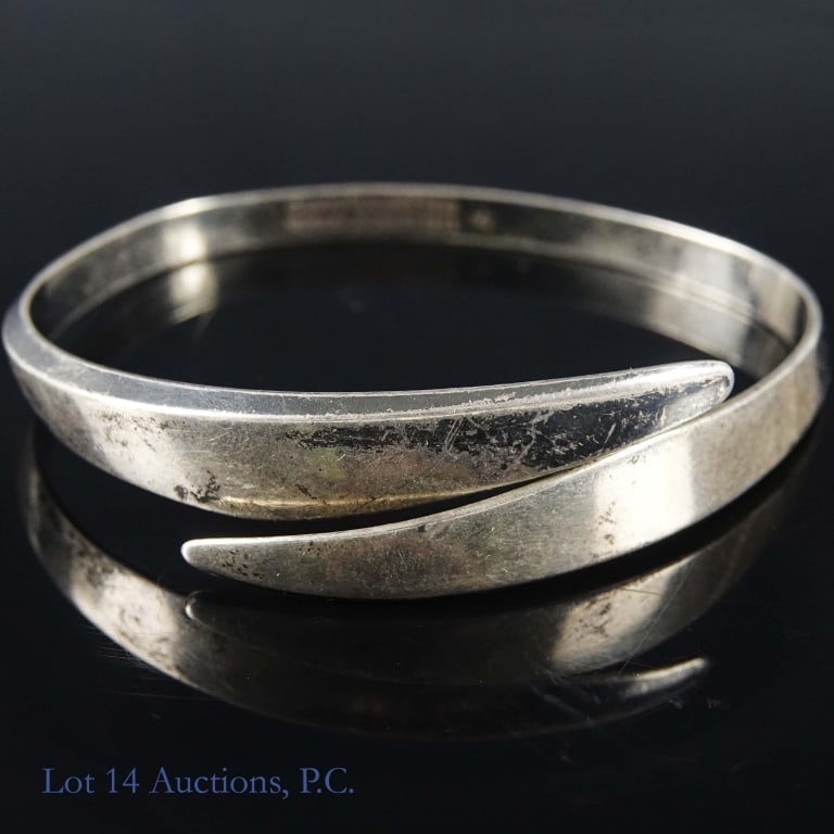 David Andersen Designer Sterling Bracelet: Sterling silver crossover style bracelet designed by Norwegian designer David Andersen in the 1960s. Weighs approximately 31.77g or 1.02 troy oz. Has an inner circumference of approximately 8".