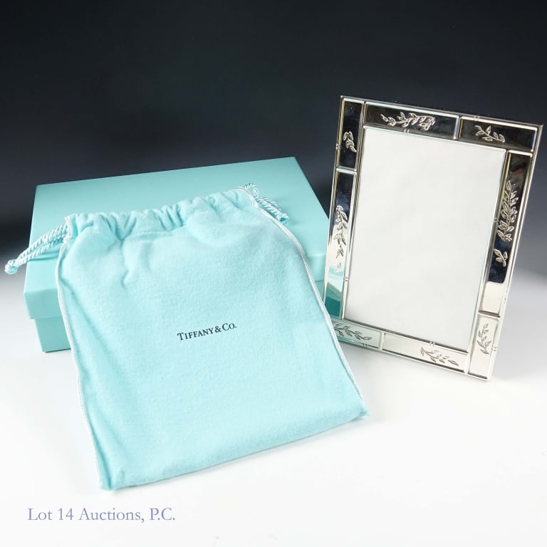2002 Tiffany & Co Sterling Silver Picture Frame: Tiffany & Co sterling silver picture frame. Bottom marked "2002 Tiffany & Co. 925 Spain". Back stand is embossed "Tiffany & Co". Overall measures 5-1/8" x 7-1/8". Center measures 3-5/8" x 5-9/16".