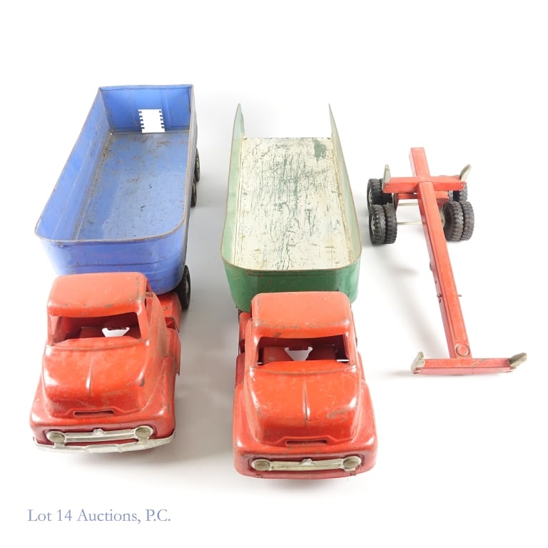 1940s/50s Dunwell Pressed Steel Trucks + Trailers: Dunwell pressed steel truck cabs (2) and trailers (3). All pieces show varying degrees of wear. Both truck cabs are red. Blue grain hauler (may be missing piece on rear). Green Steel Carrier Co. Red L