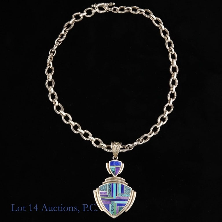 Silversmith, Inc Sterling Pendant & Chain: Sterling silver chain and pedant. Pendant has a design made up of different stones, including turquoise, lapis, and more. The back of the pendant is marked with the Silversmith logo and the word "Ster