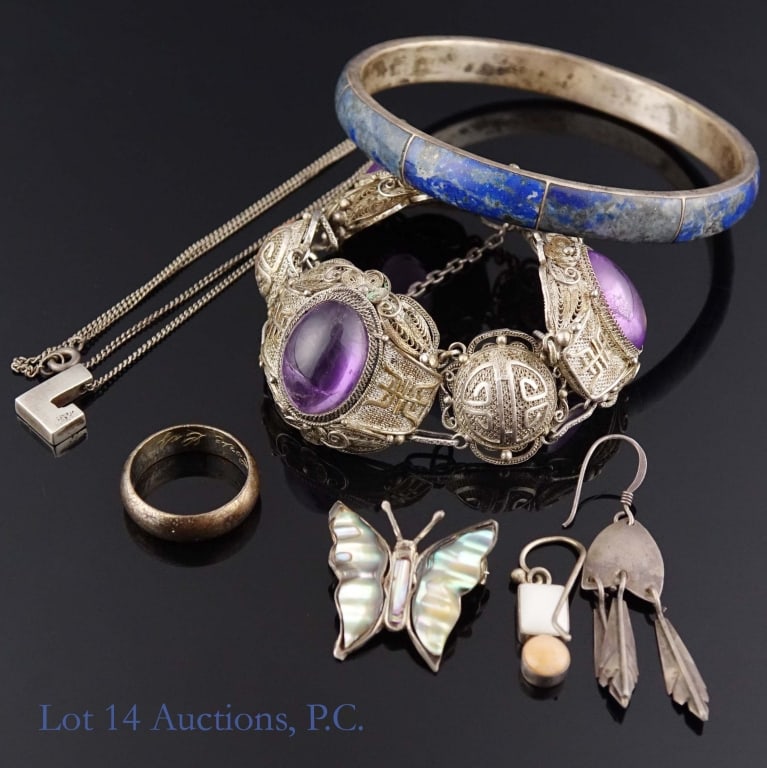 Mixed Silver and Sterling Silver Jewelry Lot: Lot of silver jewelry of various content. Lot includes: bangle with inlaid blue stones marked 950 on the inside; bracelet with purple stones marked "SILVER", an unmarked dangle earring with feathers,