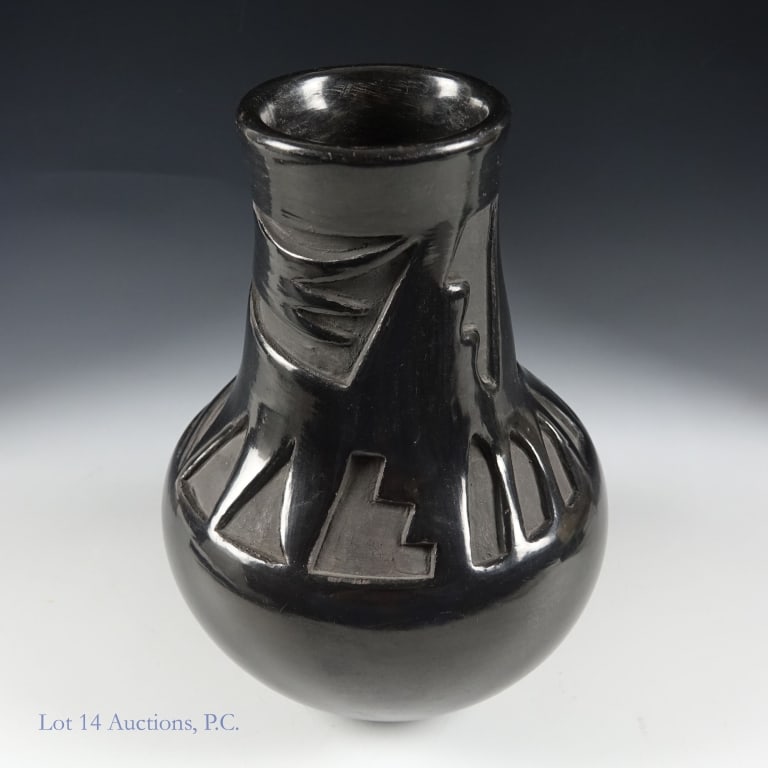 Flora Naranjo Blackware Santa Clara Pueblo Vase: One blackware vase with deep relief geometric patterns by Pueblo artist Flora Naranjo in the Santa Clara area. Measures approximately 5.25" wide and 7.25" tall. Good condition other than some age