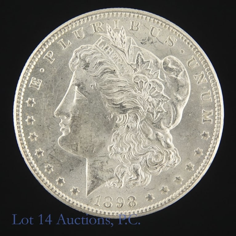 1898-O US Silver Morgan Dollar (CH BU): 1898-O United States silver Morgan dollar (New Orleans Mint). Per consigner, clean cheek in CH BU condition. Metal is 90% silver (ASW 0.7734 ozt). Mintage 4,440,000. *** Lot 14 Auctions is not a profe
