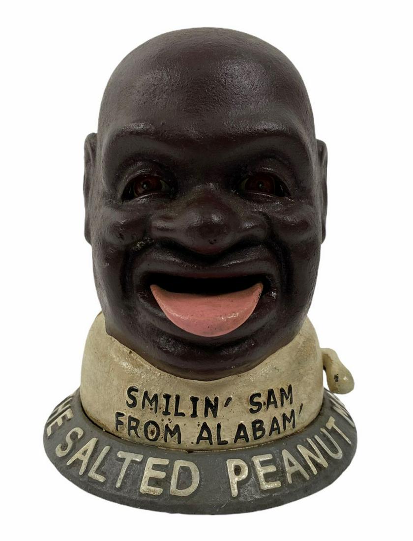 Antique "The Salted Peanut Man" Cast Iron Bank: A black americana "The Salted Peanut Man, Smilin Sam From Alabam'" mechanical cast iron coin bank. Circa: Mid/Late 20th Century. Measures: 6" Tall x 4-3/4" Diameter. Total Weight: 2.14 Kg. Recommended