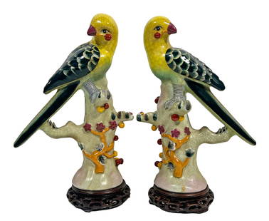 Pair of Chinese Porcelain Glazed Parrots w/ Cherry: Pair of Chinese export hand painted glazed porcelain bird figures each perched with a cherry in mouth. Each bears calligraphic chop mark underneath base. Each measures approx. 8" L x 3-1/4" W x 11" H