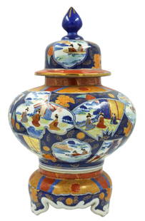 Japanese Imari Porcelain Covered Jar & Stand 18.5": Large Japanese Imari hand painted scenic covered porcelain jar seated atop a matching pedestal stand. Stamp marked underneath each piece. Dimensions: 18-1/2” Tall x 12” Diameter. Provenanc