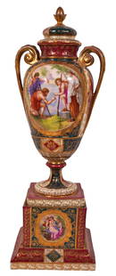 Antique Royal Vienna Porcelain Covered Urn: Antique, turn of the century Royal Vienna porcelain handled urn hand painted with a courting scene to center amongst a rouge ground detailed with gilt trimming throughout. Circa: 1890-1910. Bears blue